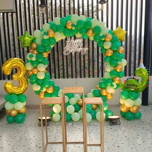 Green and Gold Dinosaur Birthday Decoration with Circular Balloon Arch and Star Foils.