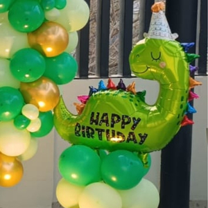 Green and Gold Dinosaur Birthday Decoration with Circular Balloon Arch and Star Foils.