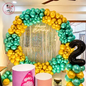 Royal birthday decoration with large balloon arch, shimmering backdrop, milestone number 2 and decorative cake stands