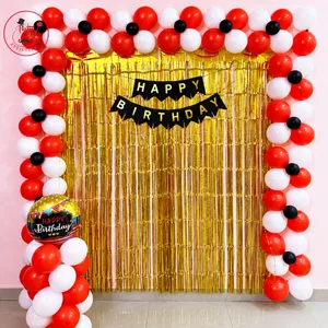 Red black and white birthday balloon decoration with golden fringe backdrop and Happy Birthday banner